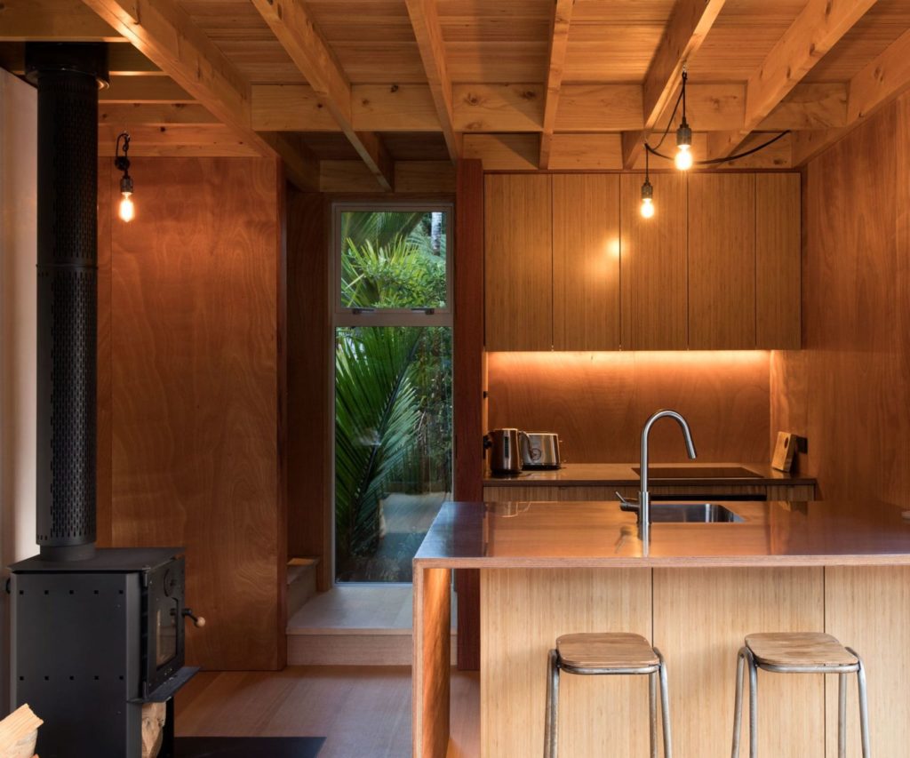 Tiny kitchen with wood fire and two bar stools
