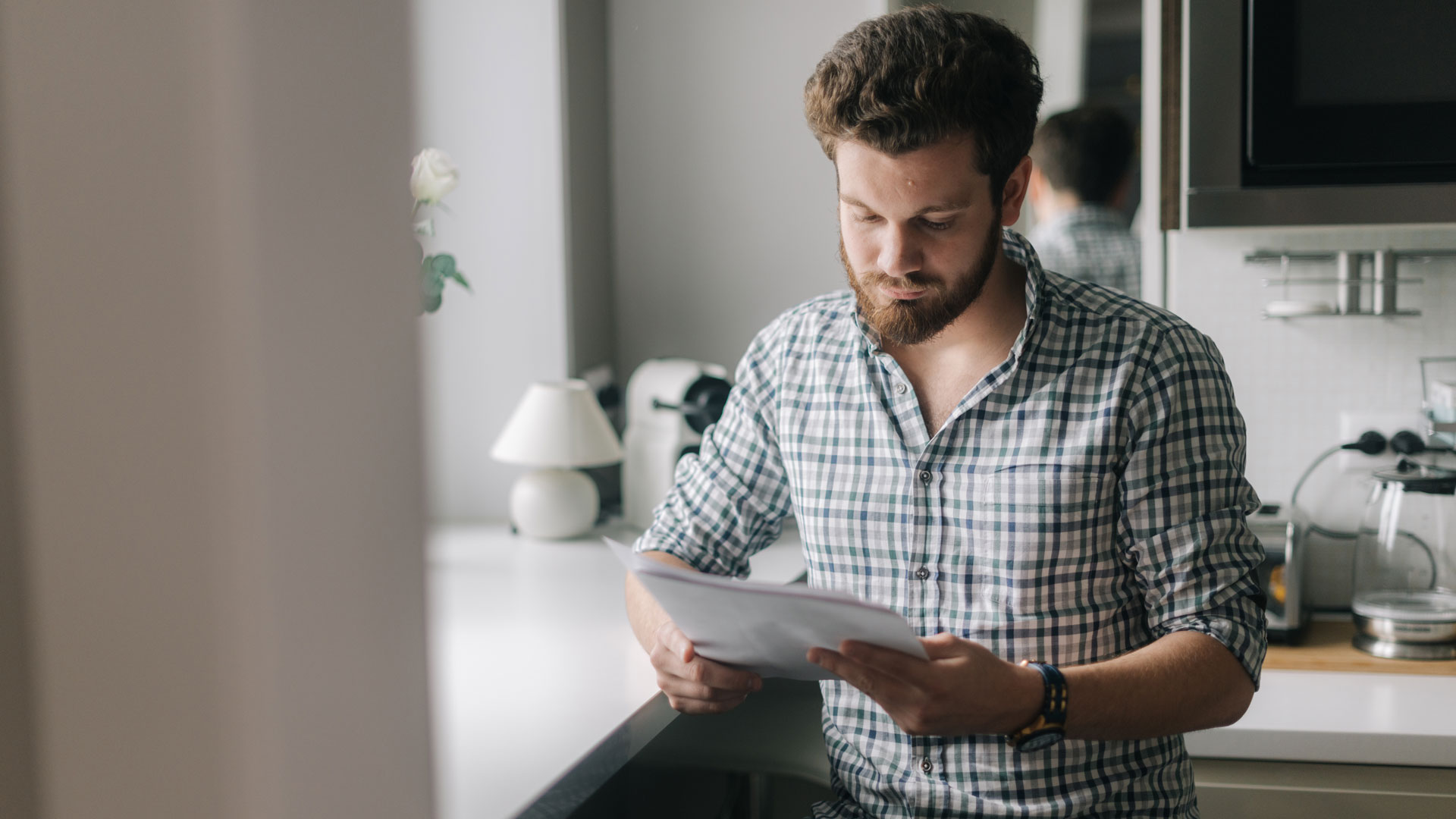 A man reading his real estate agent contract at home.