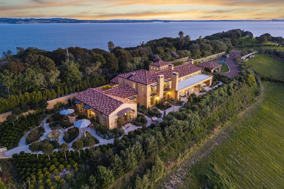Luxury Mediterranean-style mansion on Waiheke Island, Te Whau Estate, among the most expensive houses in NZ, with terracotta roofs, landscaped gardens, and sweeping views over the Hauraki Gulf.