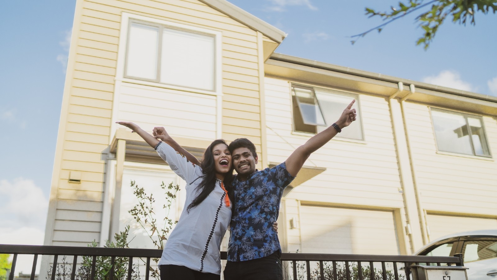 Off the plan apartment buyers. Couple in front of new home. 