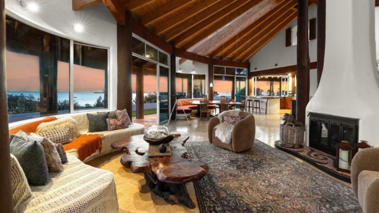 The main house was influenced by the circular form of a yurt. The main living area is one huge space with windows that wrap right around to maximise the sea view. Photo: Bayleys