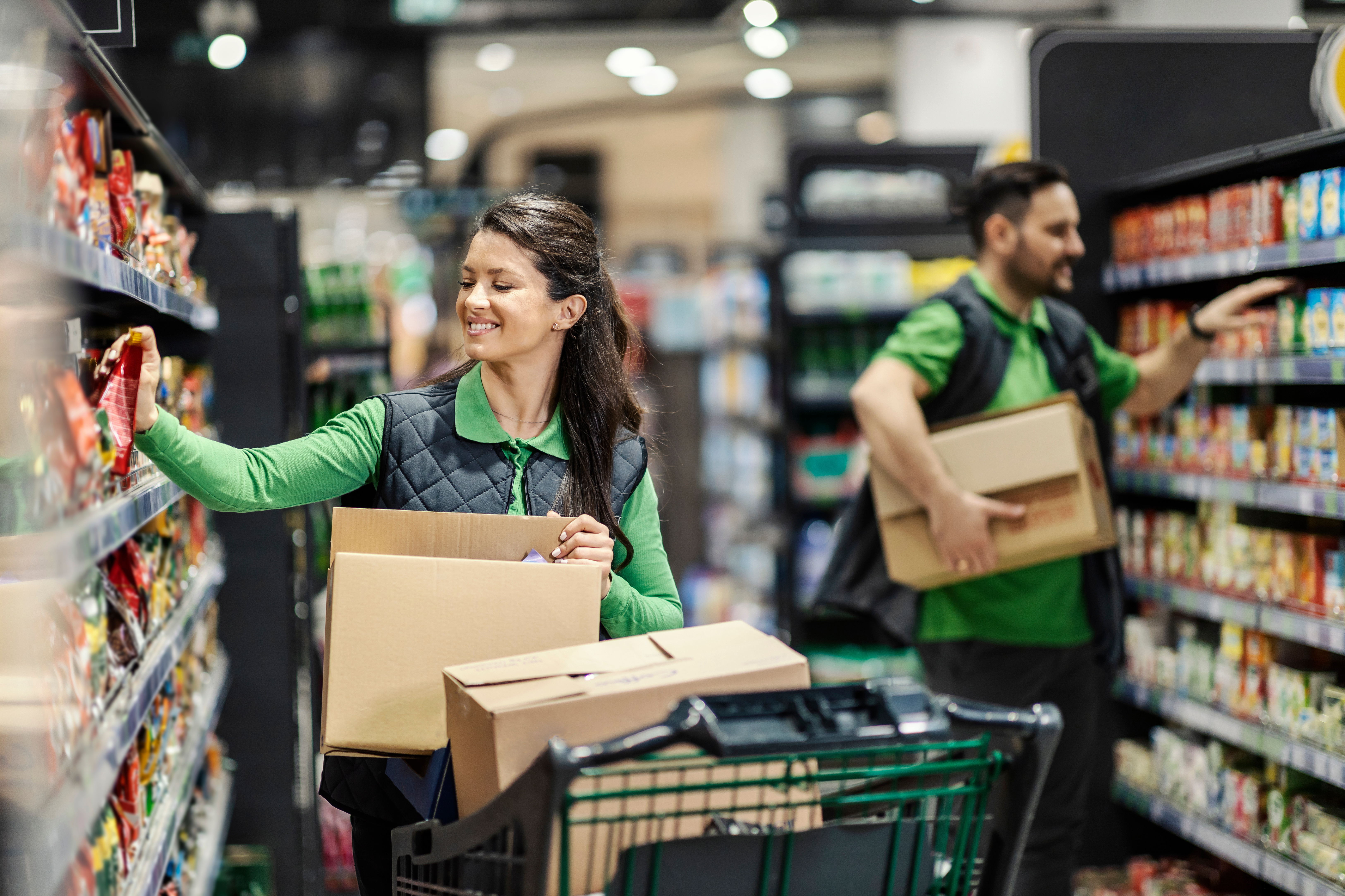 Two supermarket workers stacking shelves