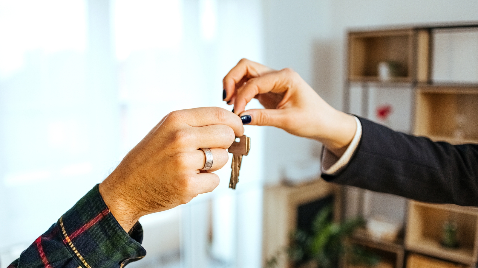 Buyer handing house key to seller. 