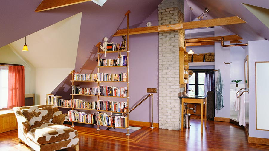 Minimalist modern New Zealand home interior, with a bookshelf that also functions as a barrier to stop people falling down the stairs.