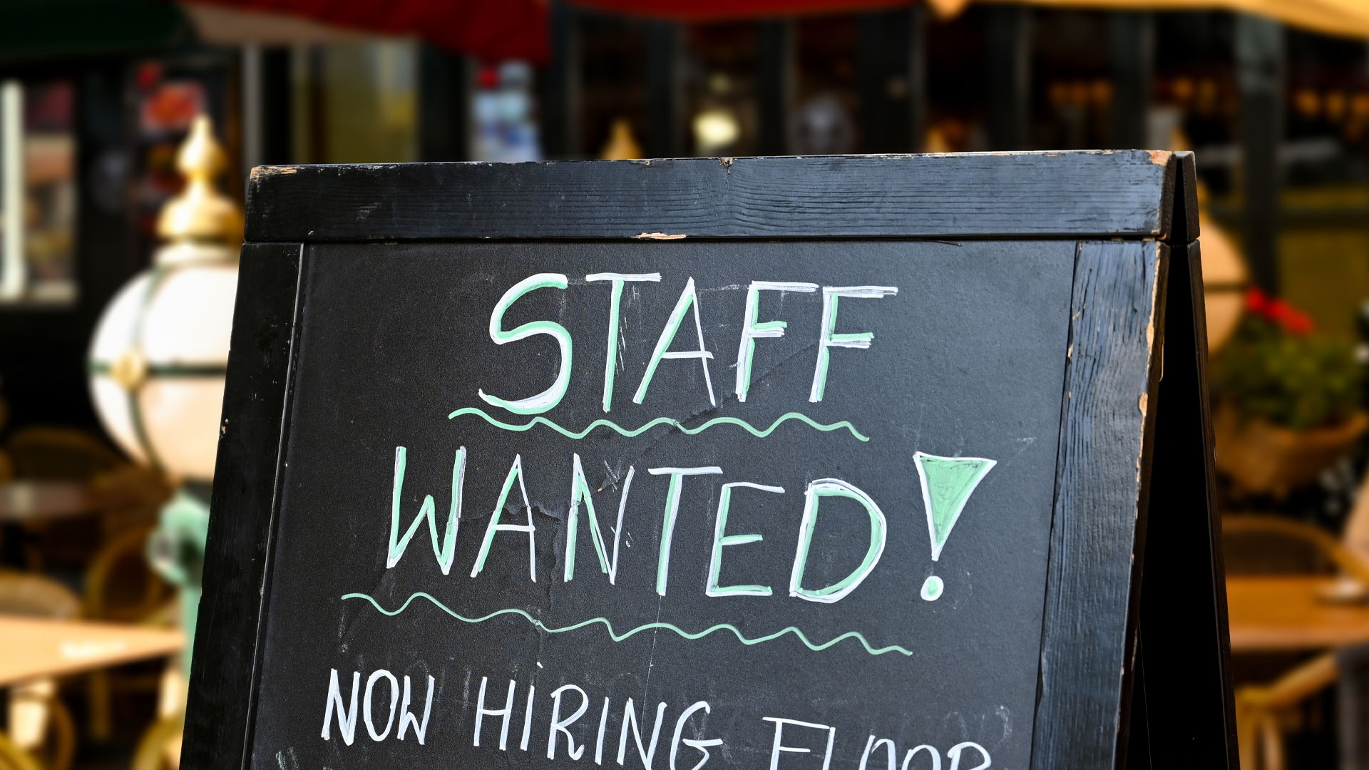Blackboard outside a restaurant with the words "Staff Wanted!" written on it.