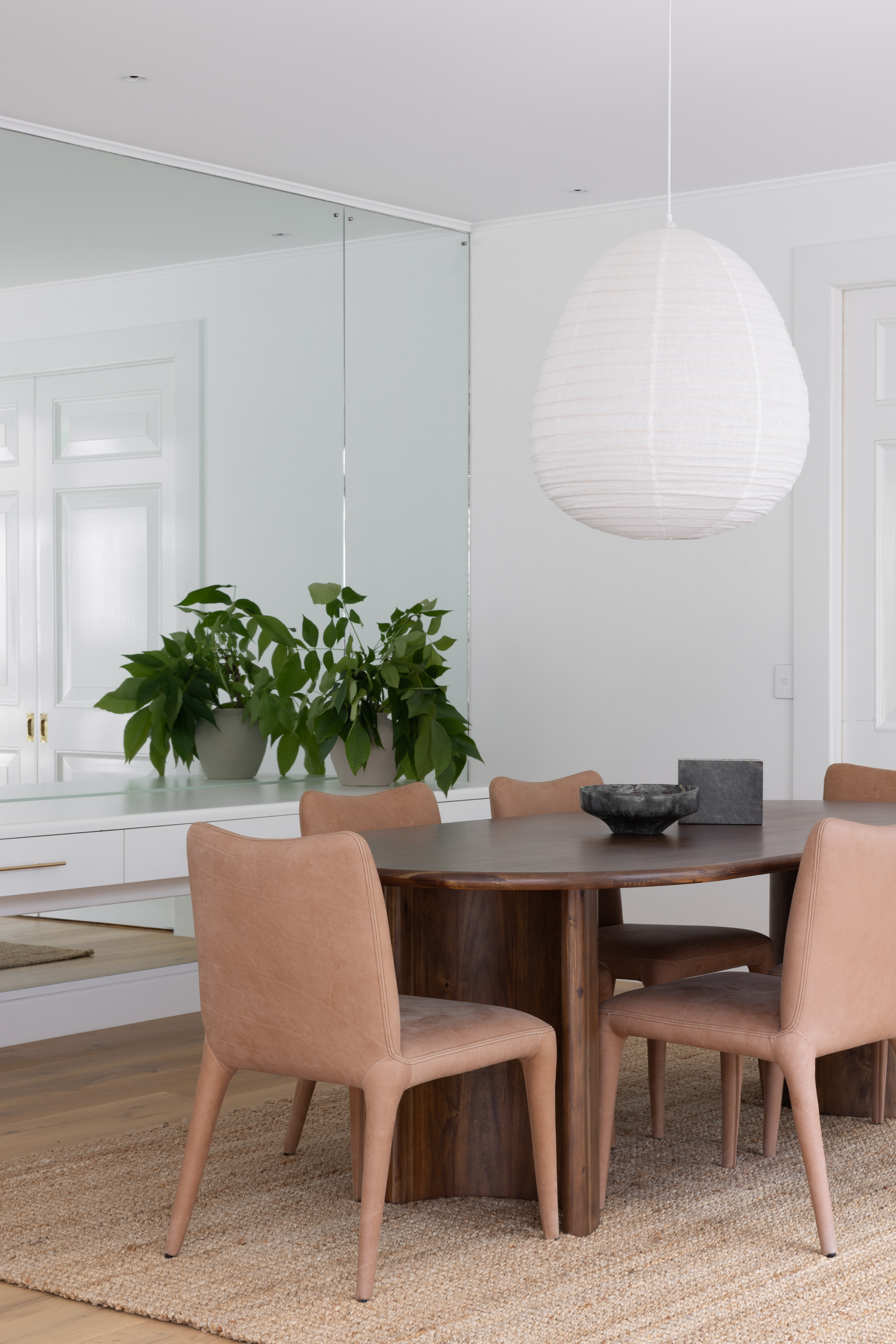 The dining room’s mirrored wall and floating cabinet were inherited, but were sharpened up with fresh paint and handles. Before renovating, the space was closed off to the kitchen, so connecting walls were opened for a more practical flow. The Cara dining table and chairs are from Coco Republic, the bowl and candle holder from BoConcept, the Koru rug from Freedom Furniture, and the linen lantern is from Home Lab Store.