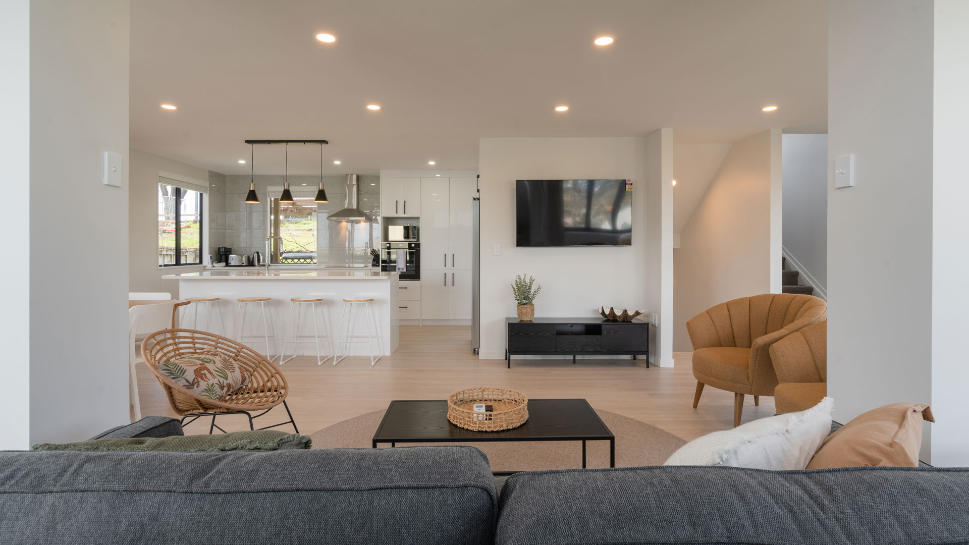 The interior of a modern NZ property with an open-plan kitchen and living room.