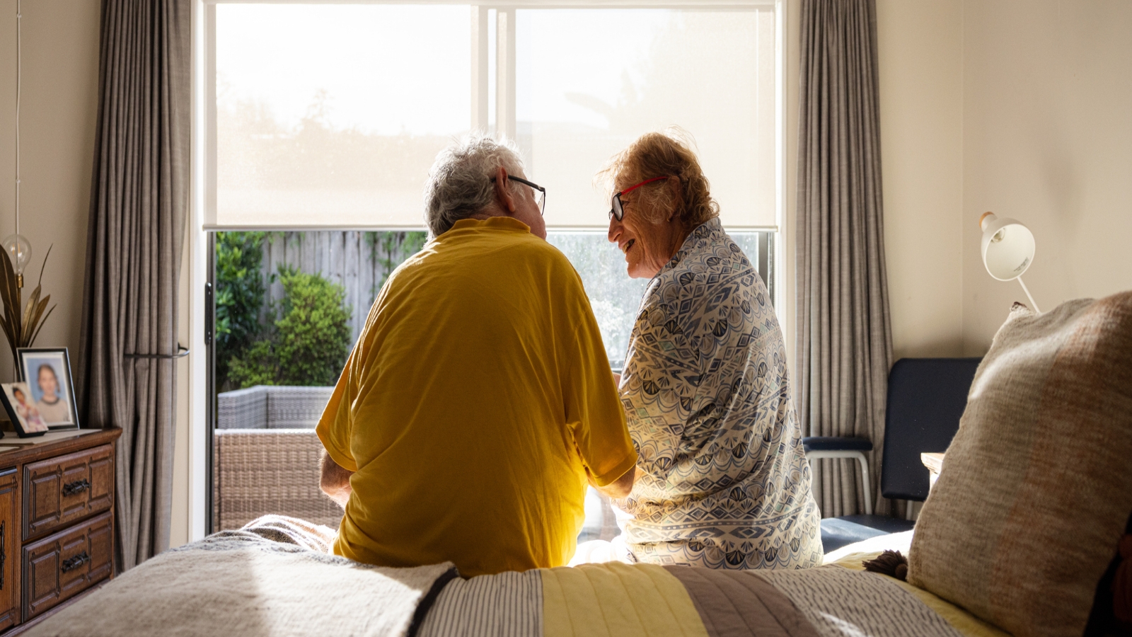 Elderly couple looking out window. 