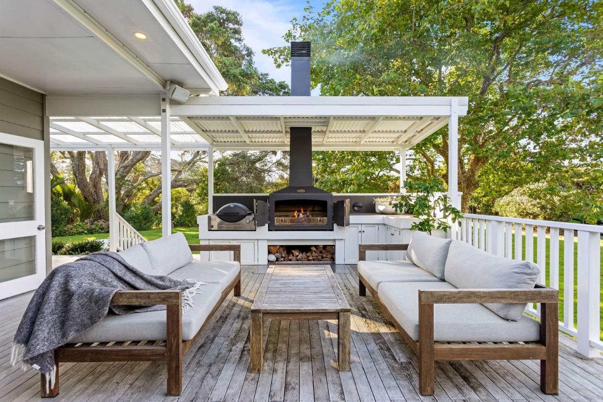 A pizza oven and barbecue are part of the covered outdoor “kitchen” at one end of the large deck.