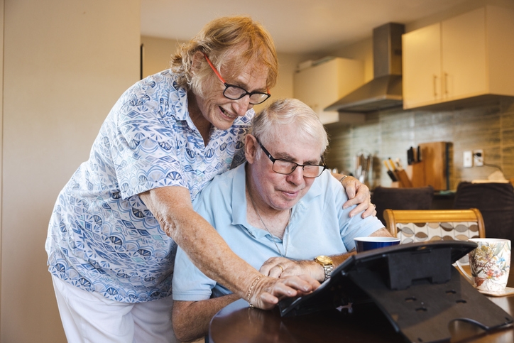 Elderly couple looking at retirement home options on an ipad