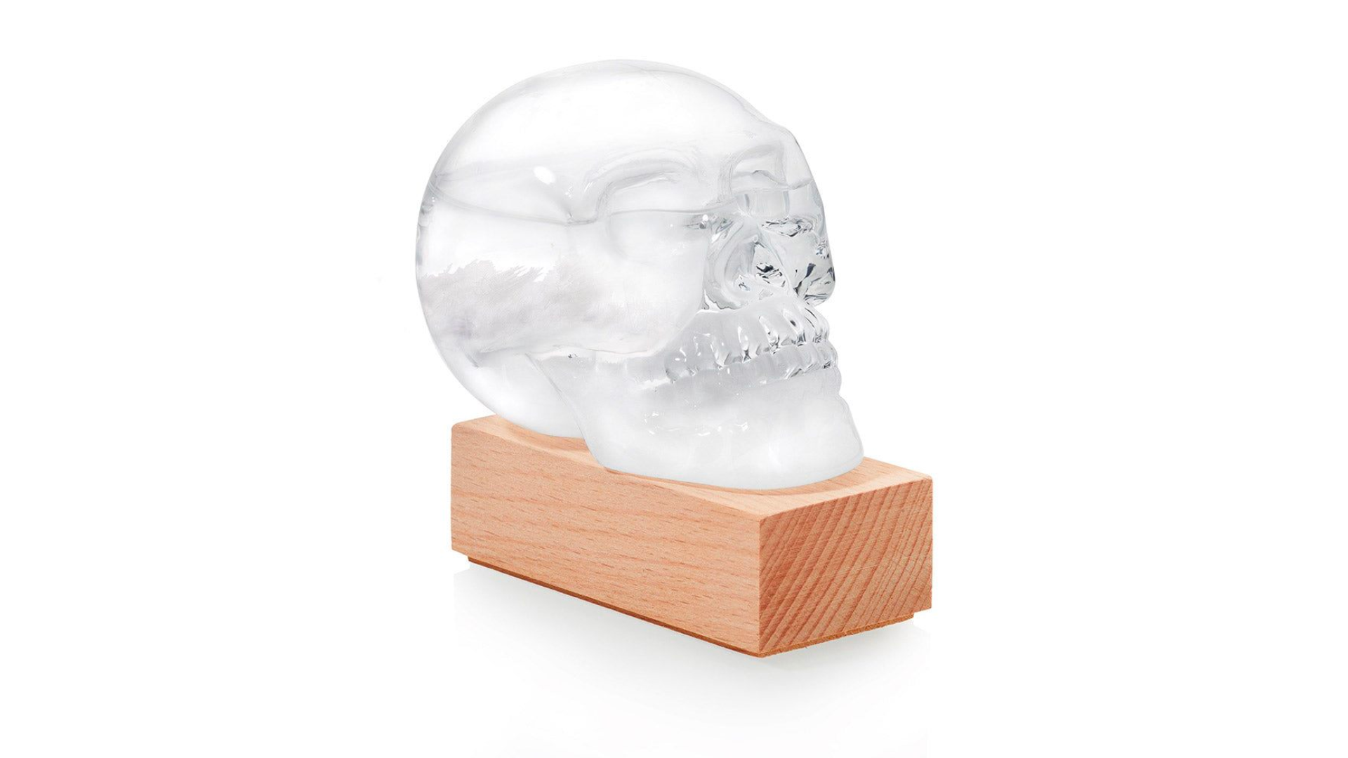 Skull shaped ice cube on a wooden stand.