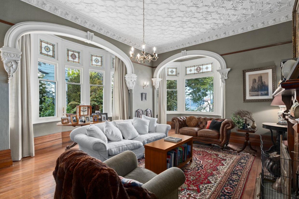 Living room has grand arched windows. 
