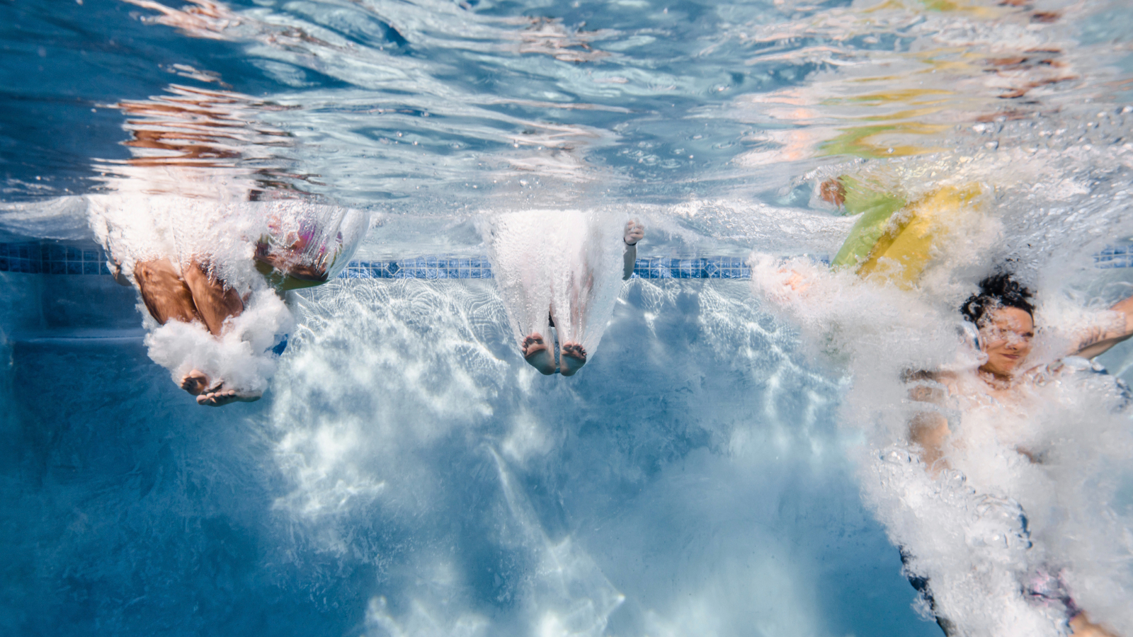 Kids jumping into pool.