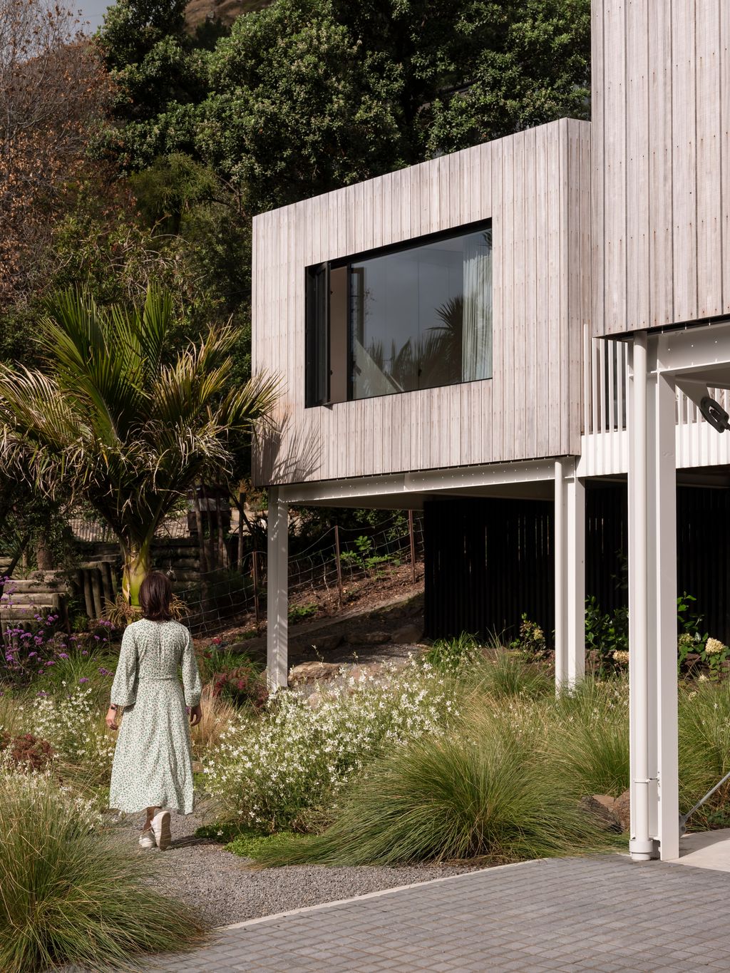 Woman walking beside house under bedroom window.