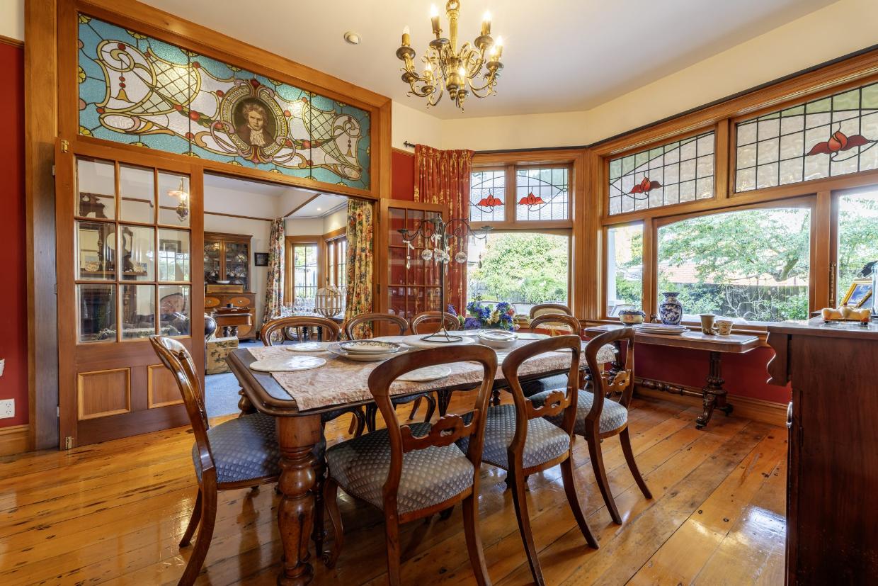 Beautiful timber floors and joinery and stunning stained glass panels are special features of the formal living and dining areas. Photo: Harcourts