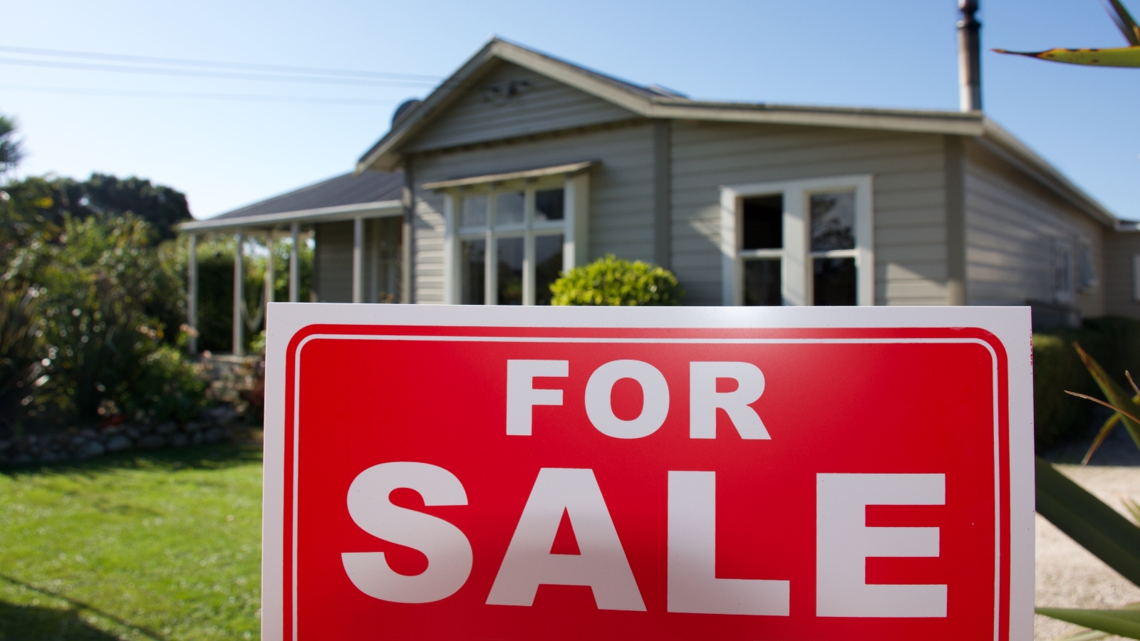 For sale sign in front of house. 