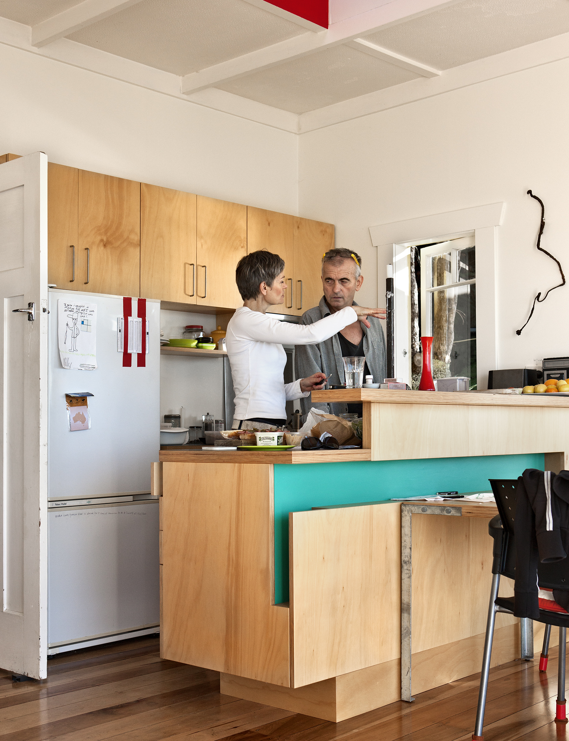 Two people standing in a kitchen