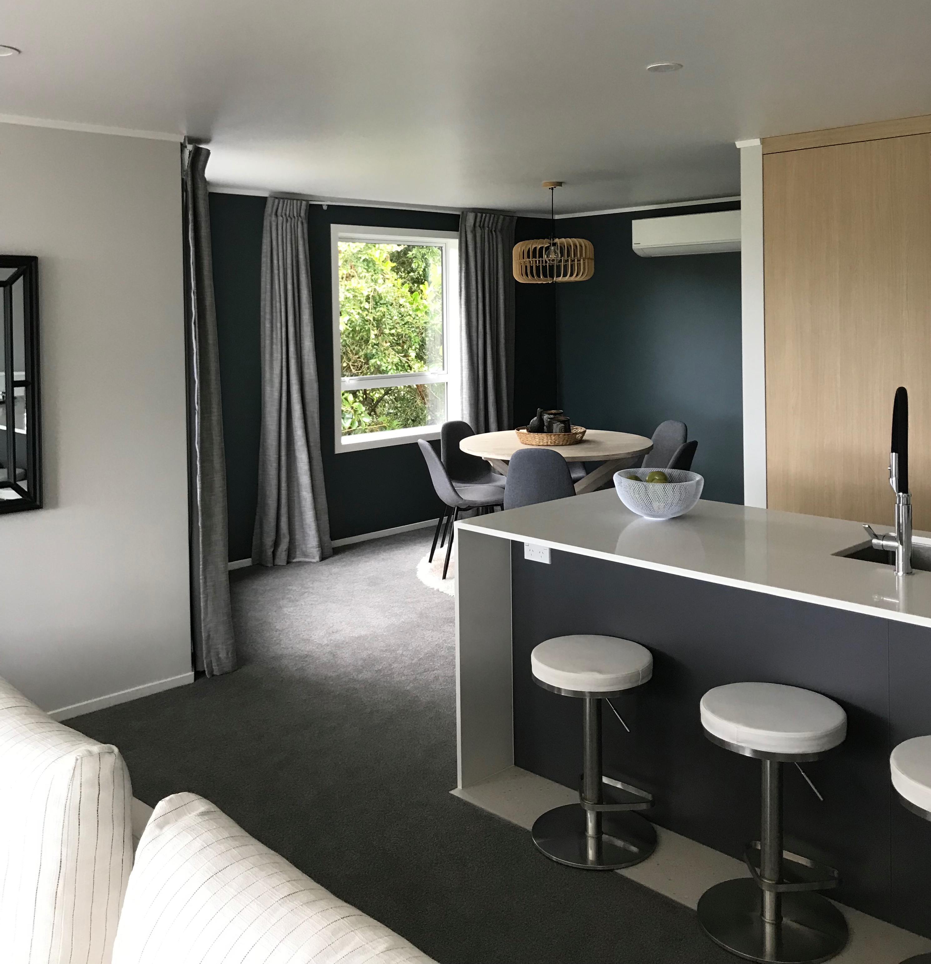 A clear grey kitchen with bar stools 