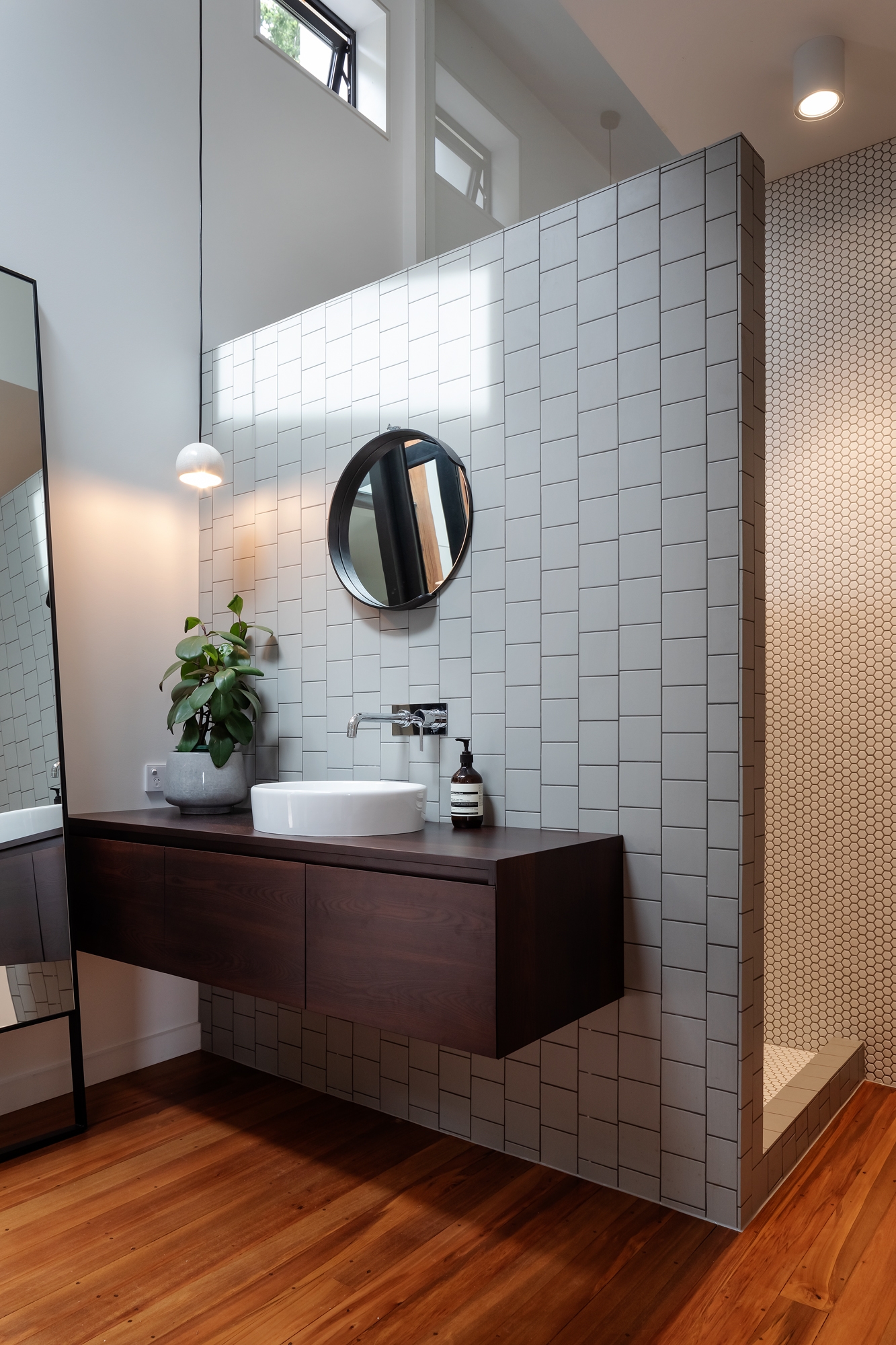 A pony wall conceals plumbing for both the vanity and shower in this compact family bathroom. Photo: Patrick Reynolds