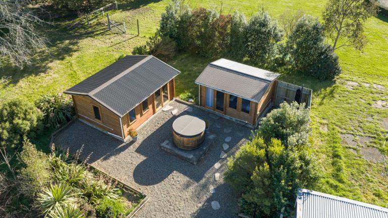 The two cabins with a cedar hot tub. Photo: HARCOURTS/TRADE ME