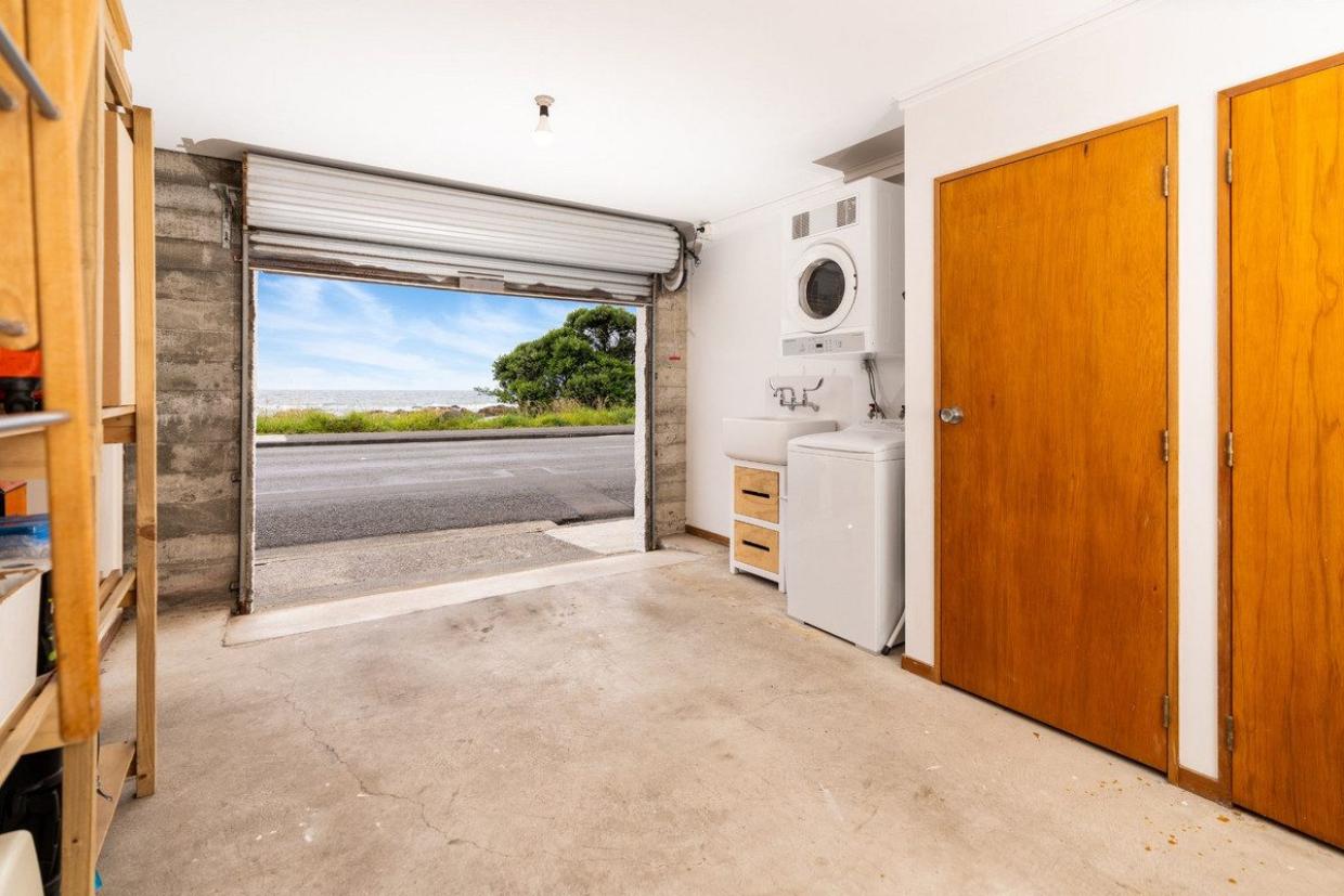 The laundry is positioned in the garage, which has two doors for two vehicles. Photo: Lowe & Co
