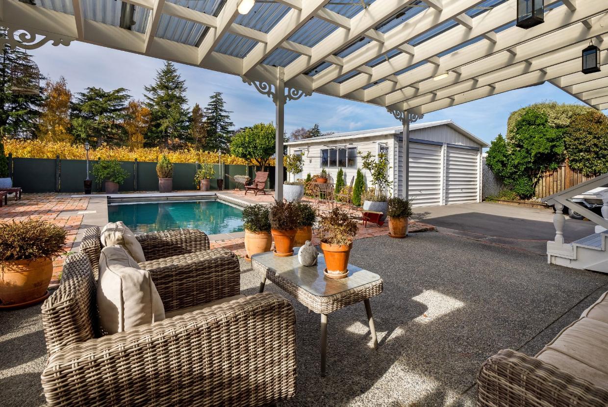 The exterior of the property includes a pool and seating.