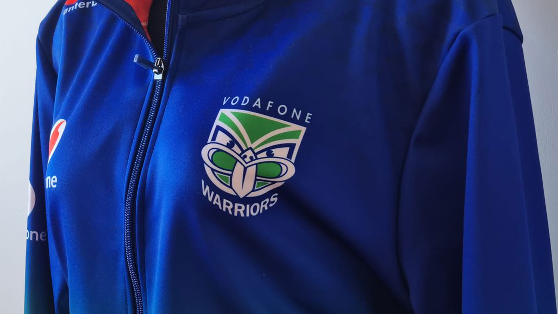 Blue hoodie with the New Zealand Warriors team logo on it.