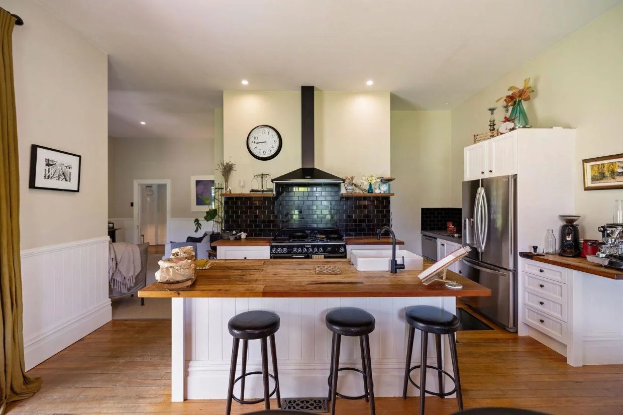 The kitchen space is stylishly decorated in neutrals with dark colour accents. 