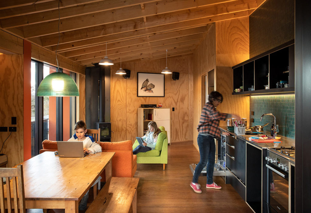 Family doing everyday things inside their DoC hut inspired home