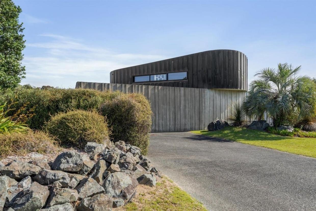 This Ōmaha beach house turns its back to the street to open up on the opposite side. 