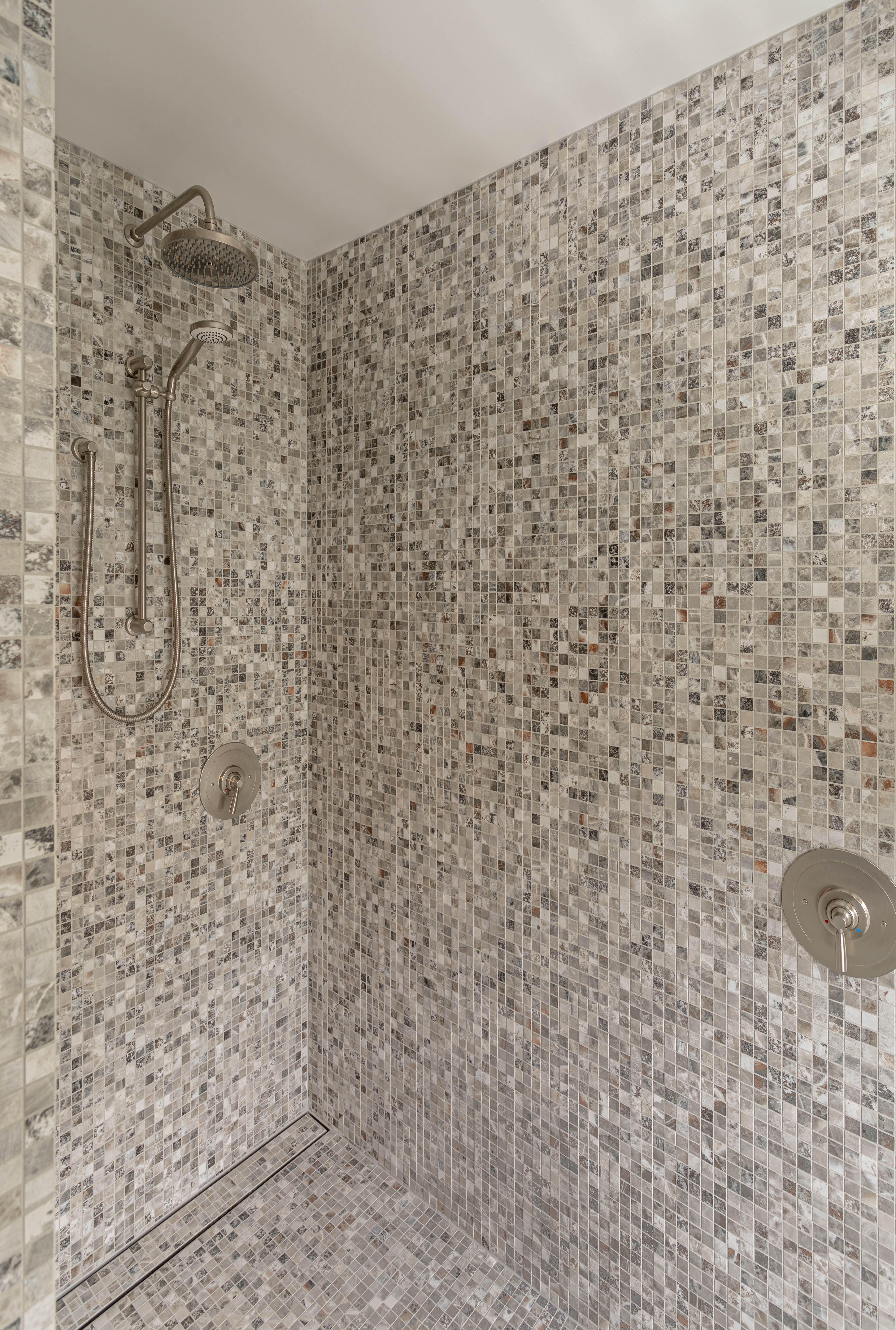 In this Auckland bathroom in a home designed by Jessop Architects, mosaic tiles across the floor and walls create a beautiful visual continuity. Image: John Williams