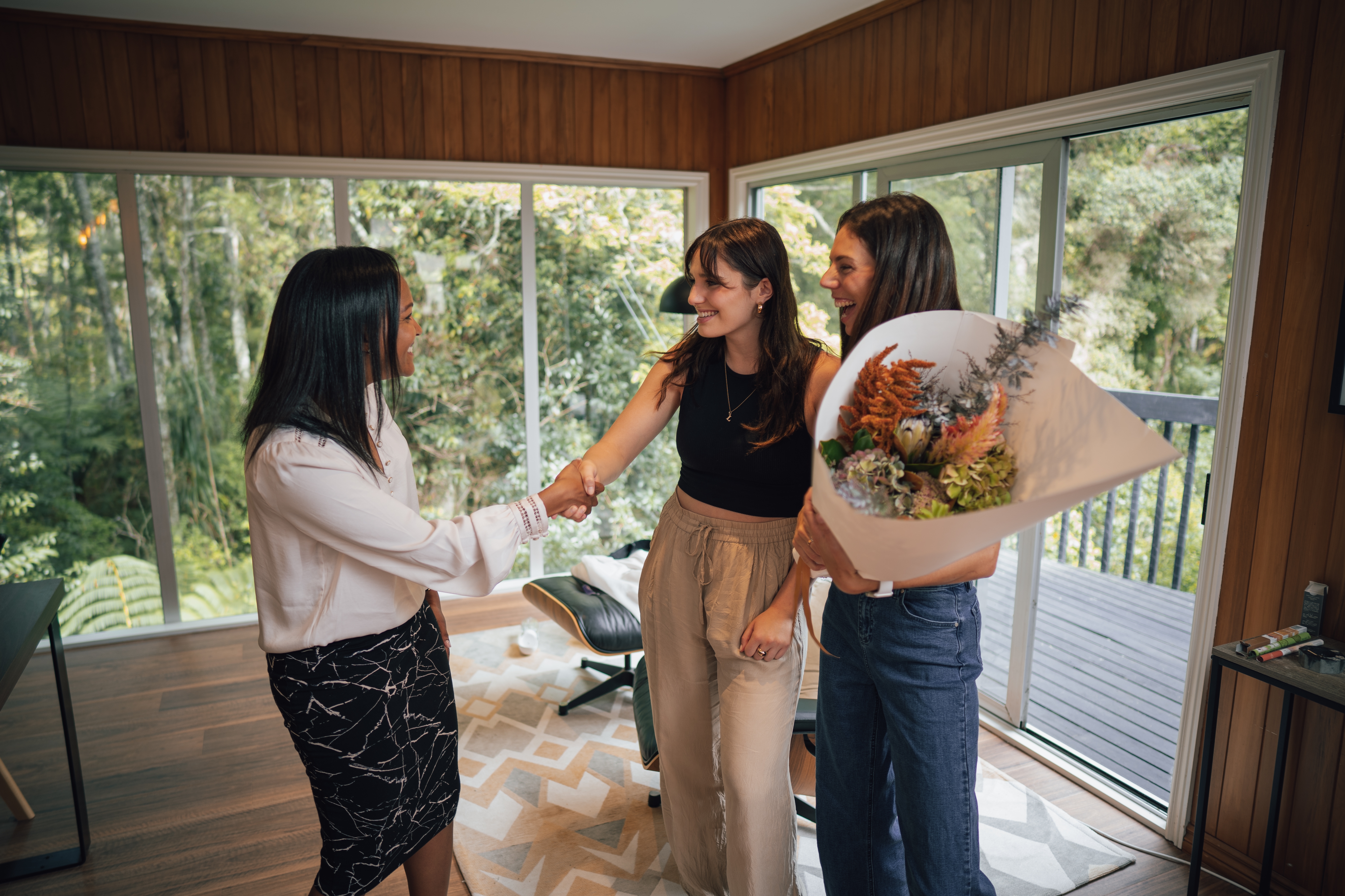 A couple shaking hands with a real estate agent when looking to sell a property.