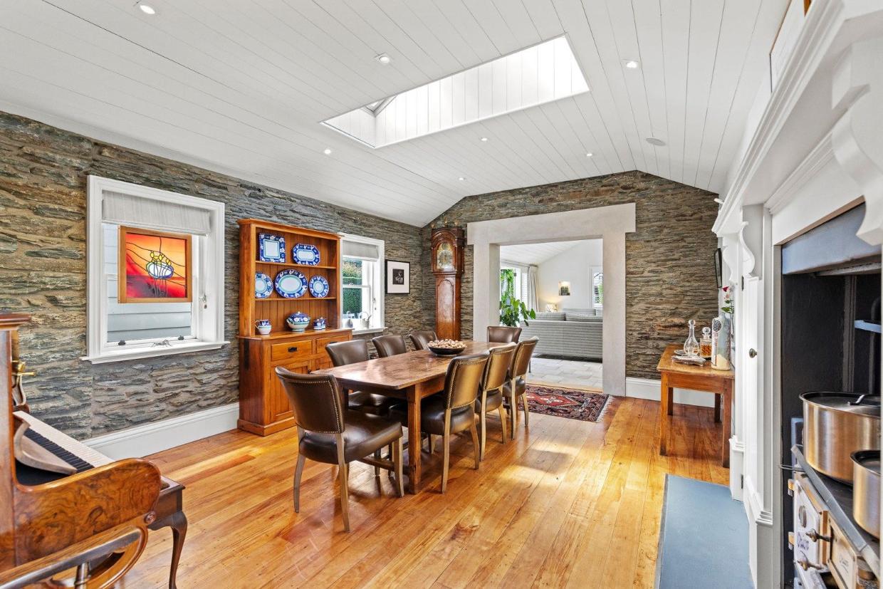 The cottage features schist walls and match-lined ceilings.