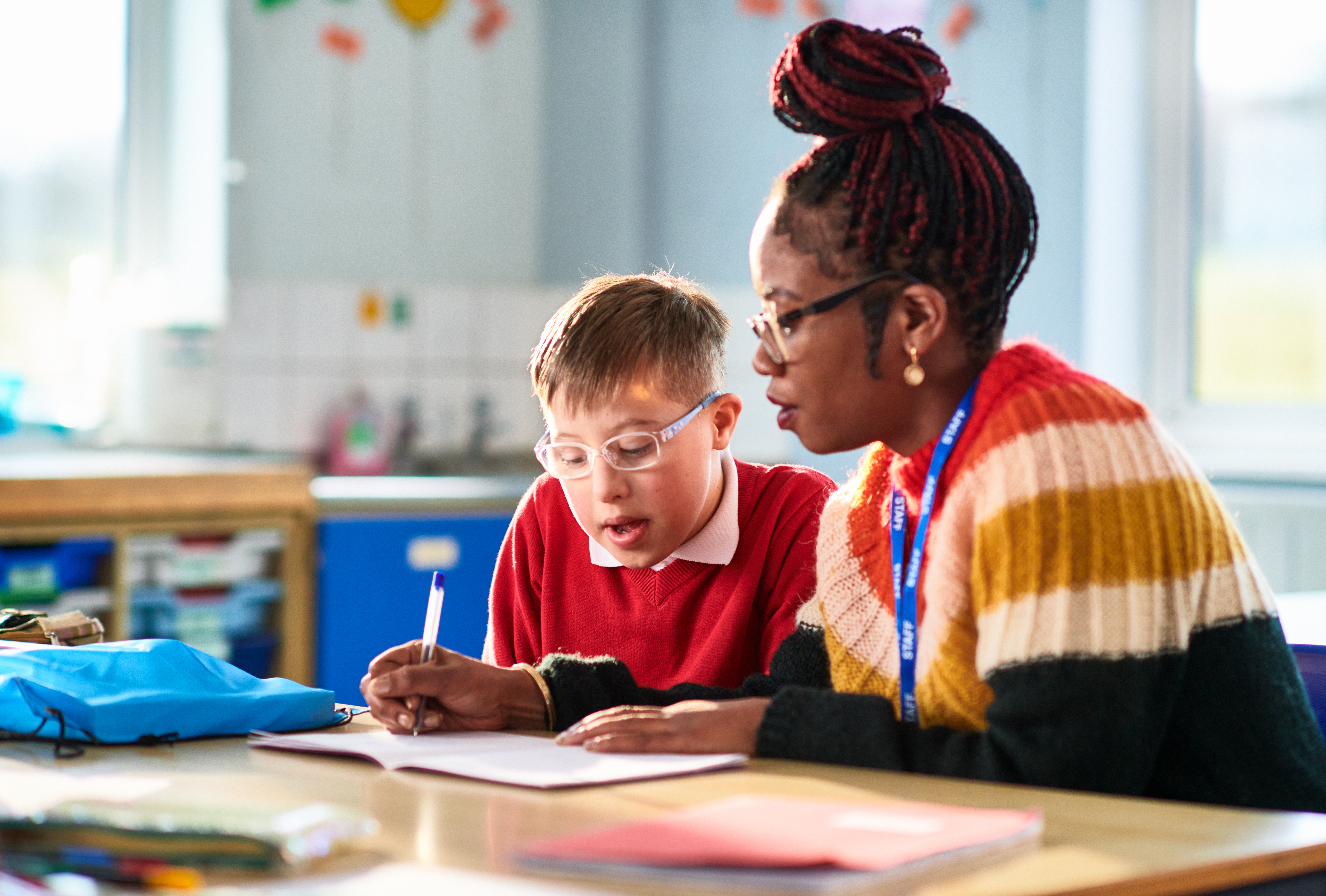 Female teacher helping young boy in the classroom