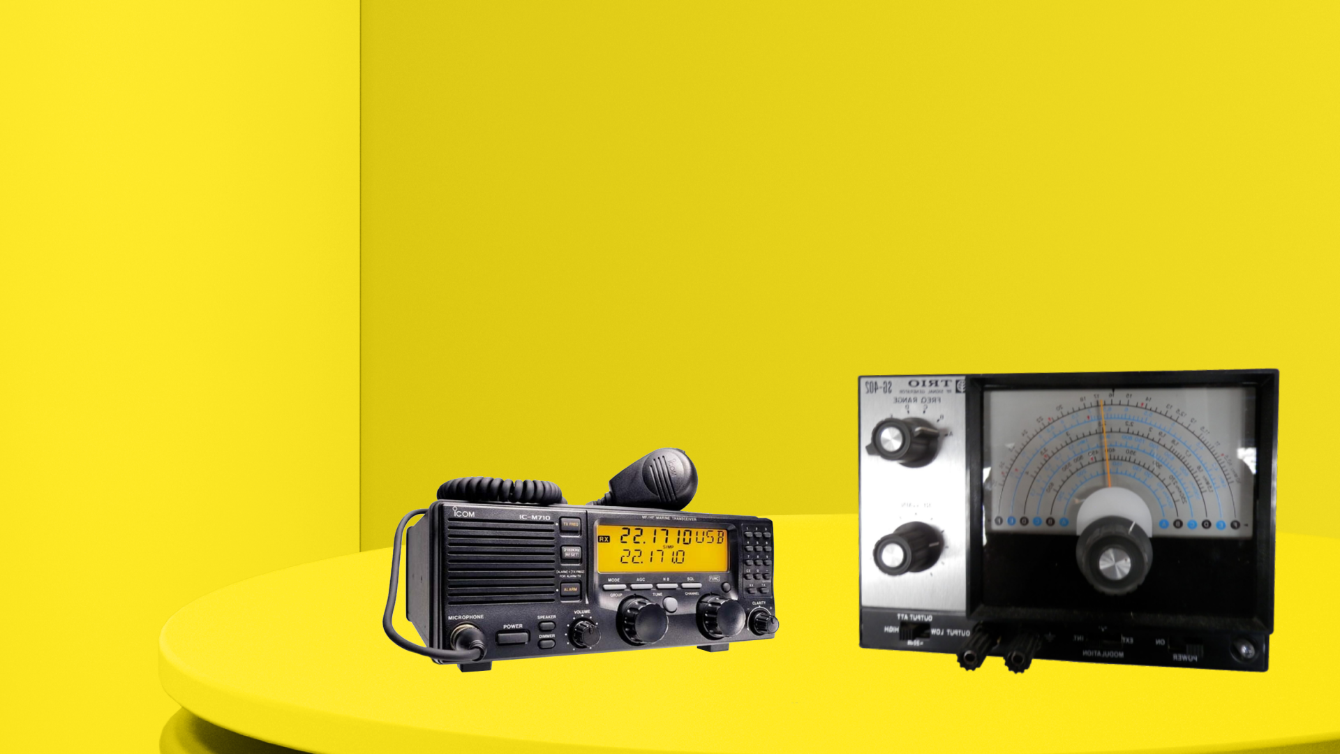Two radio devices on a yellow plinth in a yellow room. 