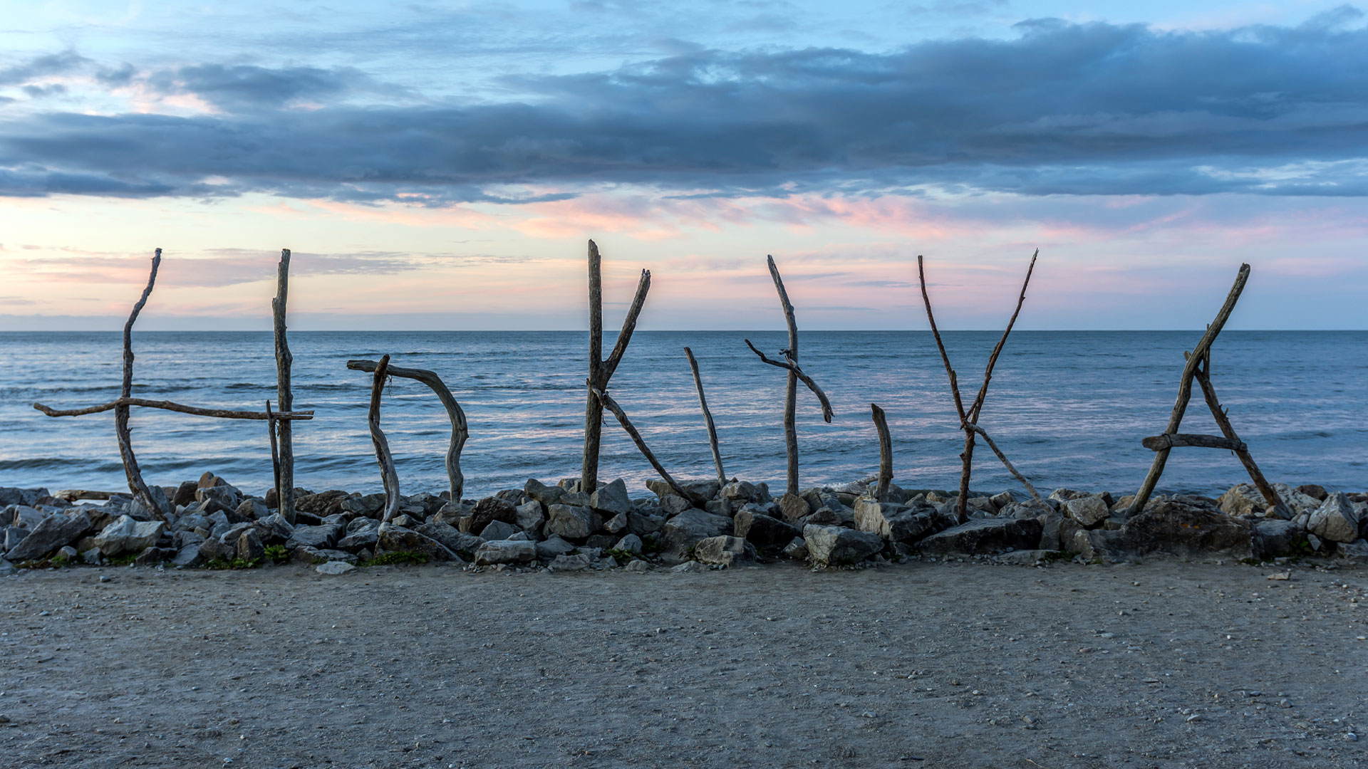 The Hokitika sign, made of driftwood, spelling out the name of the town, on the beach.