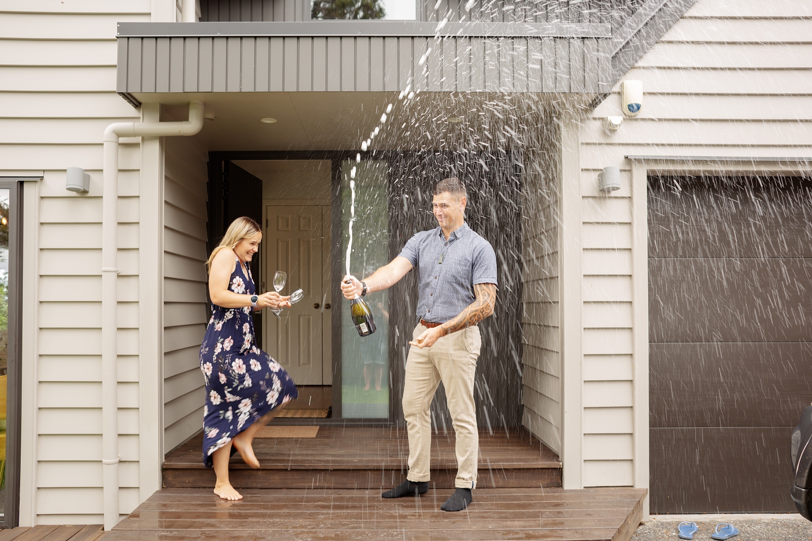 Couple pop champagne after buying a house