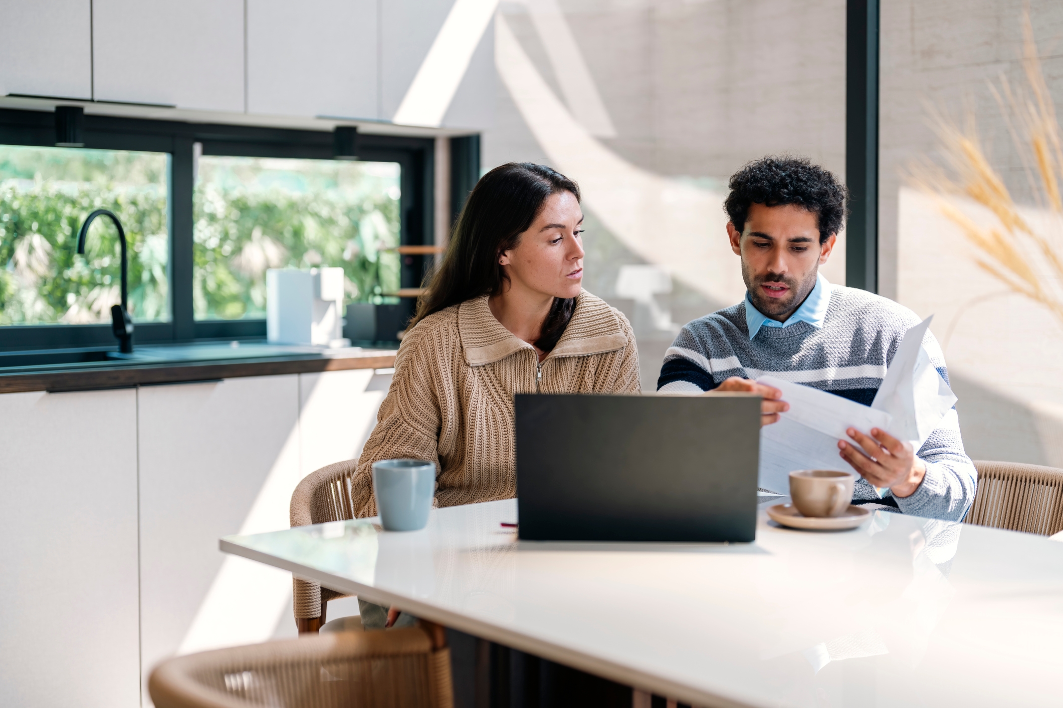 A couple reviewing documents together at home, discussing how to divide assets after separation in New Zealand.