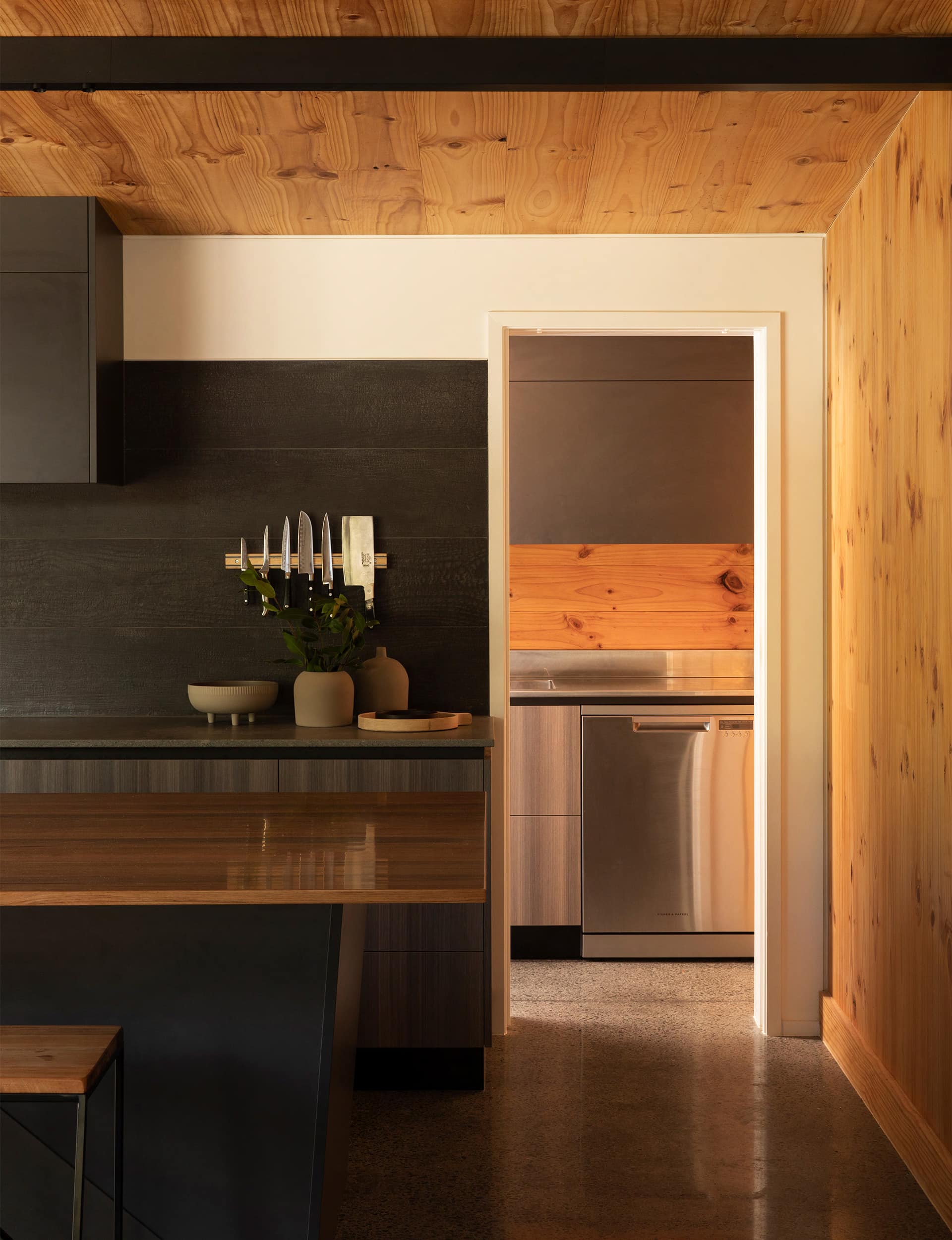 Modern pantry with wooden shelving and cabinetry, seamlessly blending natural wood tones for a contemporary yet warm look.