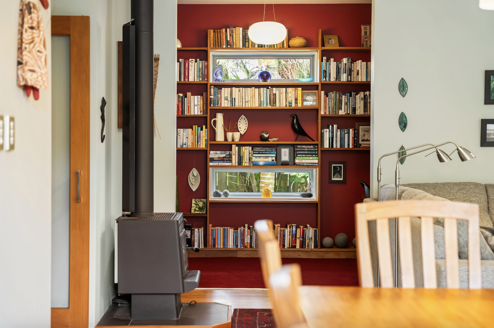 Red bookshelf and fireplace in eco home 