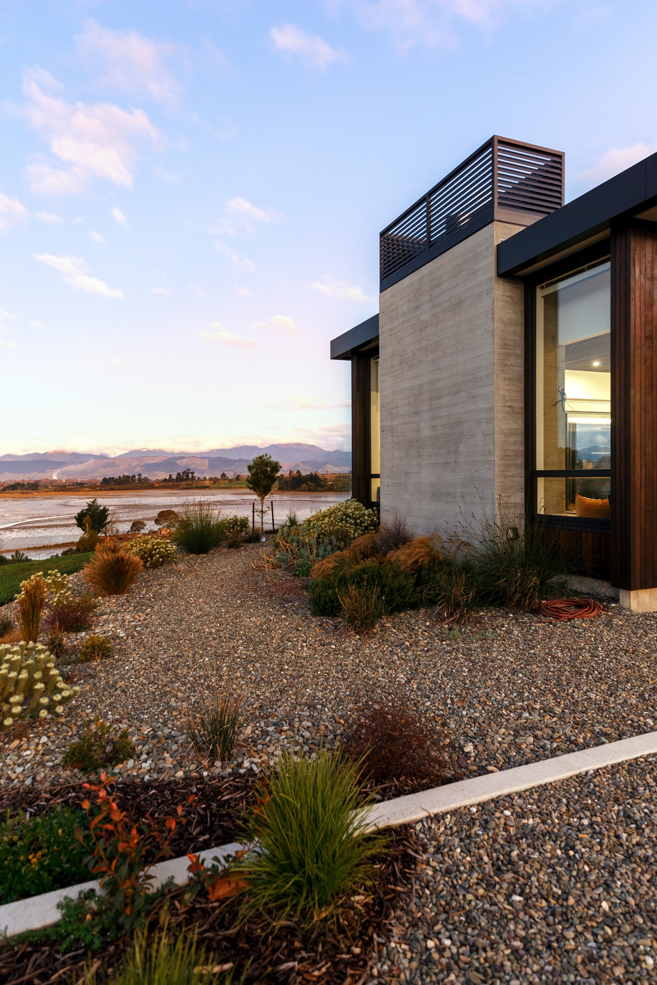 Modern sustainable home sitting adjacent to a tidal estuary