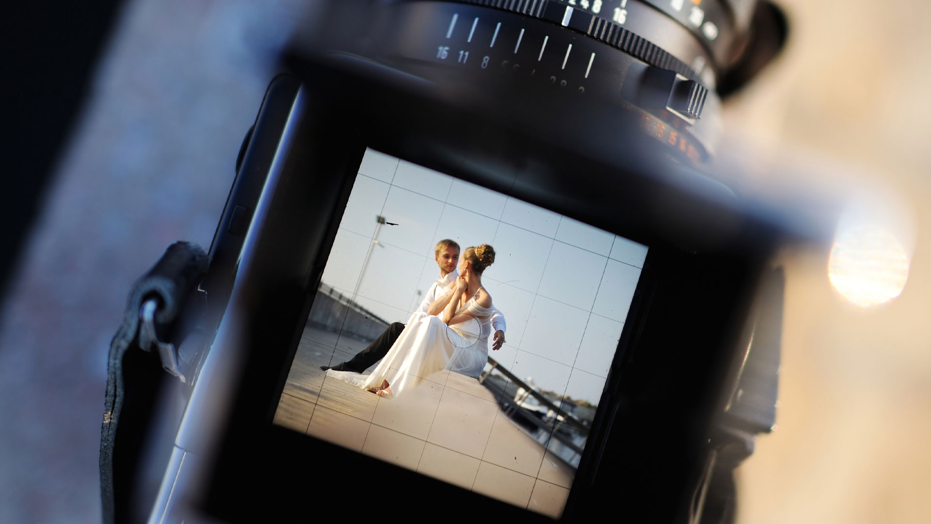 Photo of a camera's playback screen showing a couple on their wedding day in the sun.
