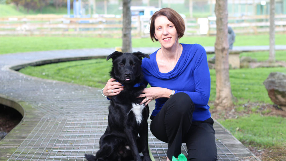 SPCA CEO Andrea Midgen and a black dog.