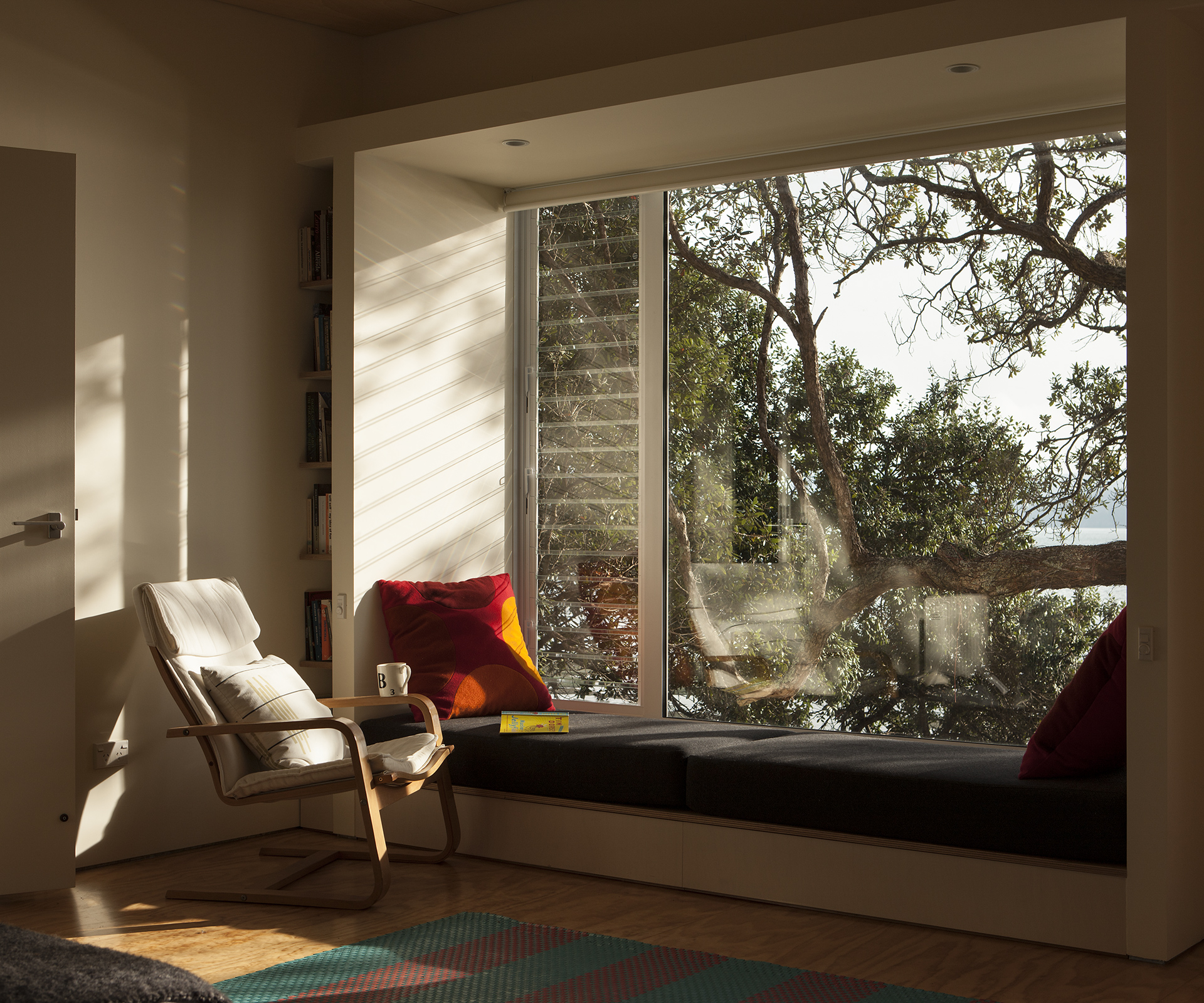 A chair placed next to a large window looking out to the sea