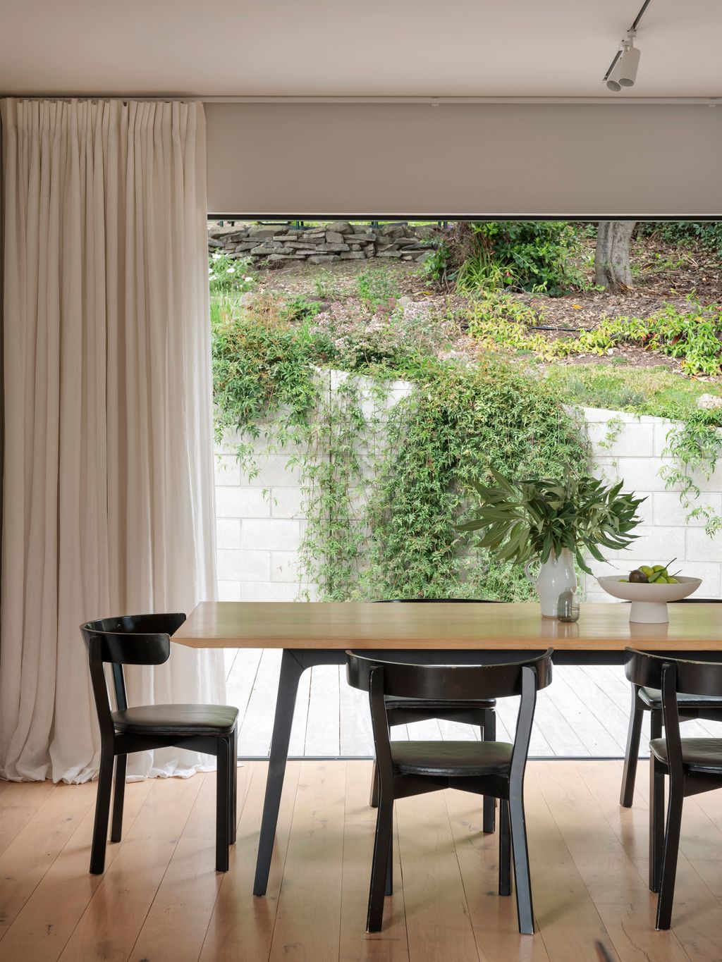 Dining area opening to courtyard with sunlight.
