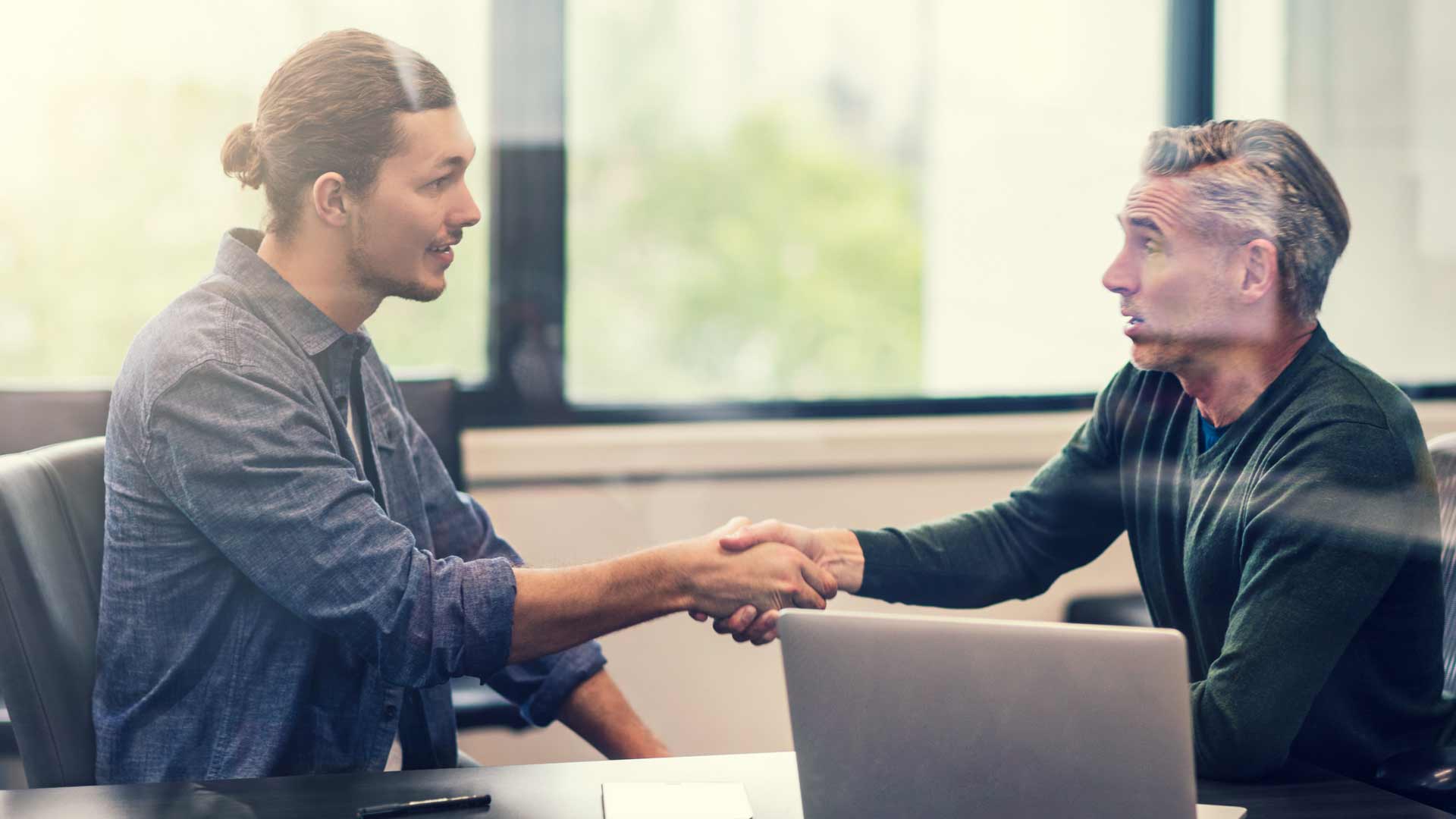 Job hunter shaking hands with interviewer.