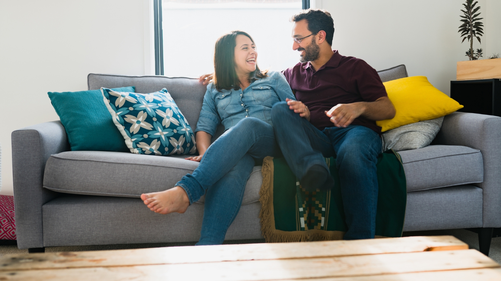 Couple sitting on couch smiling. 