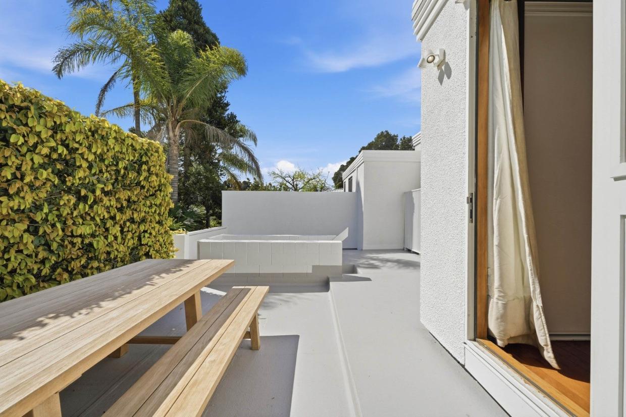 The open-plan living and dining area, accented by timber flooring, opens directly onto a large terrace.