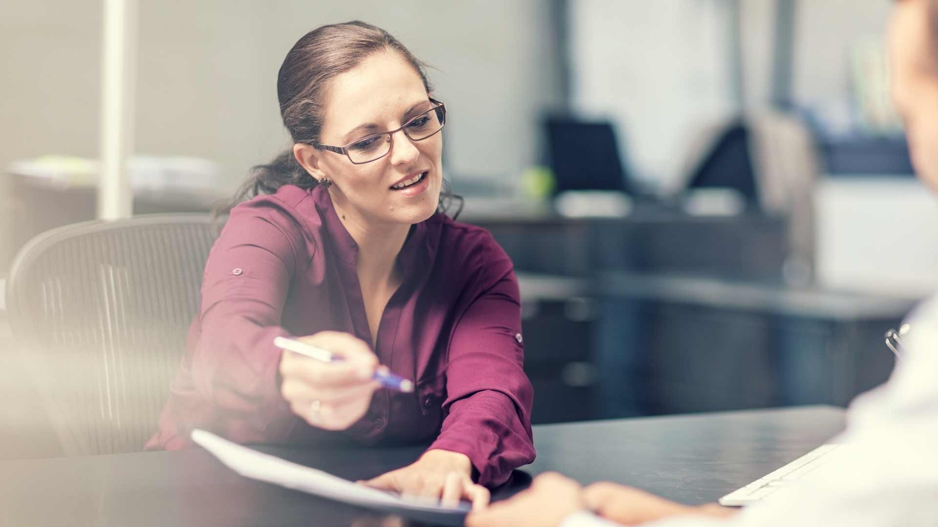 Accountant explaining a balance sheet to a colleague.