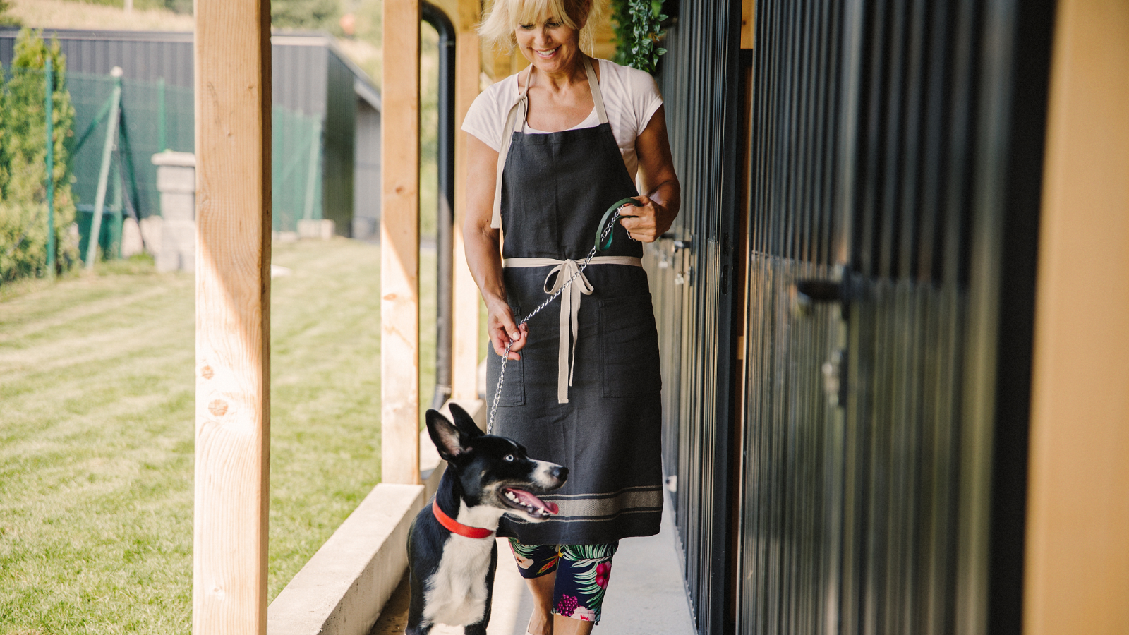 Lady leading dog on lead. 